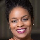 Headshot of Nicole Morris Johnson, smiling and wearing shiny earrings. 
