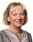 Photo shows a blond person smiling at the camera. 