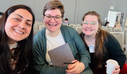 Left to Right: Amelia Gayle (holding a coffee cup and wearing glasses), PhD Candidate, Romance Languages and Literatures; Kailey McDonald,(holding a notepad and pen wearing glasses) PhD Candidate,, Global Gender & Sexuality Studies. 