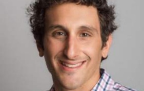 Man with dark hair, smiling at the camera. 