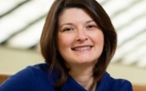 Photo shows a woman smiling at the camera. 
