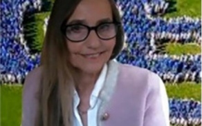 Woman wearing glasses, smiling at the camera. 