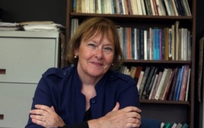 Photo shows a woman smiling at the camera. 