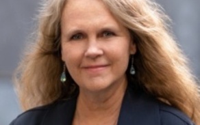Photo shows a woman smiling at the camera. 