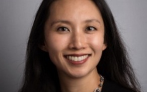 Photo shows a woman smiling at the camera. 