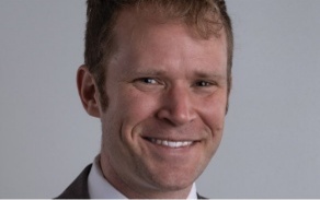 Photo shows a person smiling into the camera. 