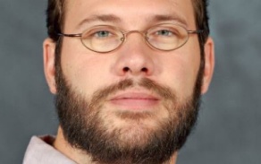 Man with short brown hair and glasses. 