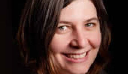 A woman with brown hair, smiling at the camera. 