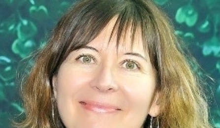 A woman with dark blonde hair, smiling at the camera. 