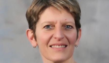 Photo shows a woman with short hair looking at the camera. 