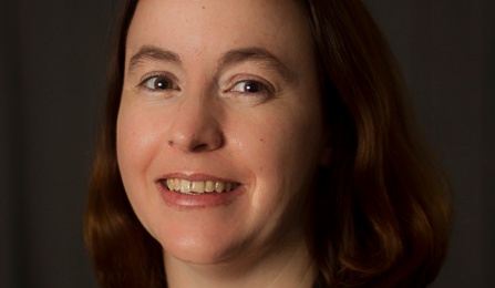 Photo shows a woman looking at the camera. 