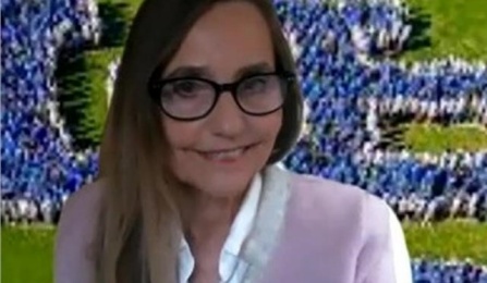 A woman with dark brown hair, wearing a pink blazer, smiling at the camera. 