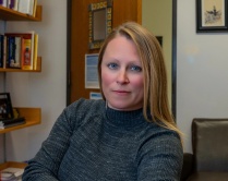 Woman with straight, light hair, smiling into the camera. 