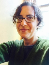 Woman with short, dark hair and glasses, looking into the camera. 