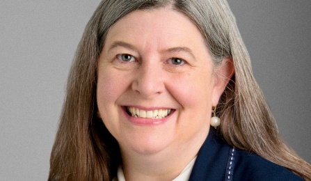 Woman in blue blazer, smiling at the camera. 