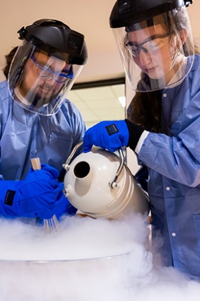 Two UB students working in a lab with chemicals. 