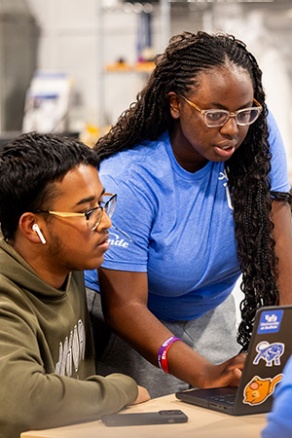 UB grads collaborating together on a laptop. 