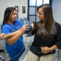A nurse is placing a blood pressure cuff on a patient in a clinic. 