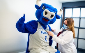 Victor E. Bull, UB's mascot, is getting a checkup in a doctor's office. 