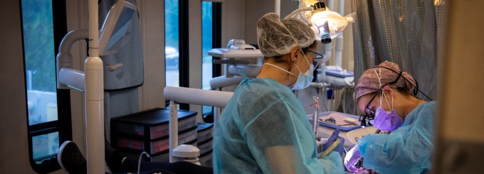 A dental assistant providing care to a patient in the van. 