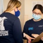 Two medical students volunteering for the Lighthouse free medical clinic discuss information on a medical chart. 