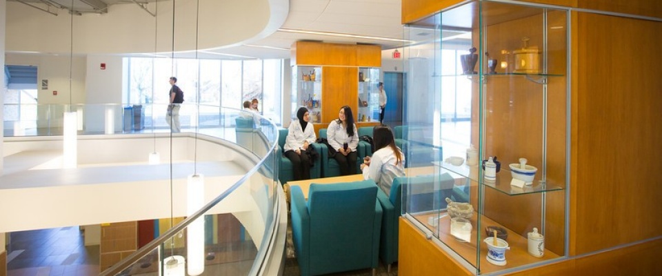 Students in white coats discussing a topic. 