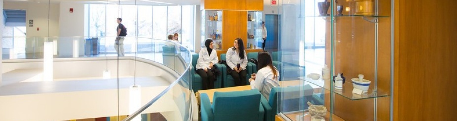 Students in white coats discussing a topic. 