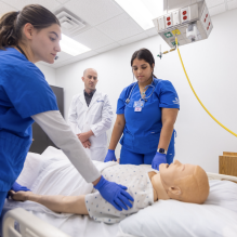 Students in a simulation room with a mannequin. 
