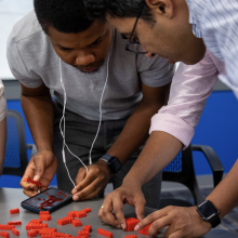 Students working with Legos during an ice breaker activity. 