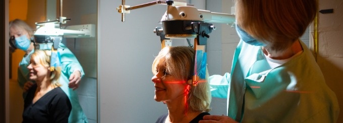 A female health care worker conducting a scan on a female patient. 