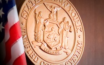 The seal of the state of New York on the wall of a courtroom. 