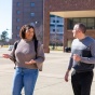 student walking outside while talking with tim matthews. 
