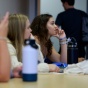 people sitting in a classroom listening intently. 