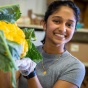 UB student Srikrithi Krishnan, a master&rsquo;s student in the School of Public Health and Health Professions, bags fresh, in-season produce for the Food Box initiative in July 2023. The group is partnering with FreshFix, a local food distributor, to bring food to people experiencing food insecurity. Photographer: Douglas Levere. 