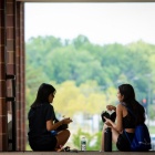 two people having lunch and a conversation while sitting on stairs. 