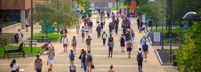 students walking on the academic spine on a warm day. 