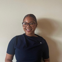 Yaide Valdez smiling in a blue blouse on a white background. 