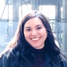 Anapaula Themann smiling in a headshot with a dark shirt and outside background. 