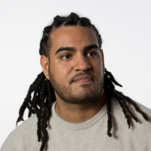 Daniel Morales-Armstrong smiling with bright shirt and white clear background. 