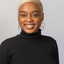 Casidy Campbell smiling in front of gray backdrop. 