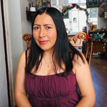 Glady Camacho-Rios smiling and sitting in a chair. 