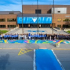 women athletes posing on a mural celebrating 50 years of title ix at UB. 