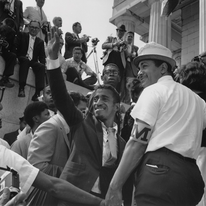 Black and white image with Davis among a crowd of people. 