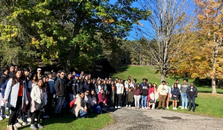 Student group at Letchworth State Park in front of trees with colorful leaves. 