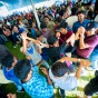 Large group of international students dancing under a big, white tent at Baird Point. 