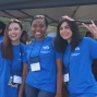 Three students outside smiling for a photo. 