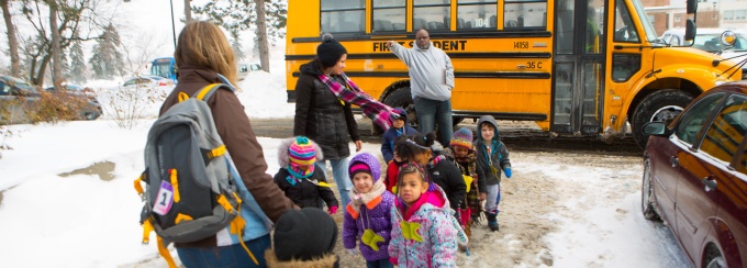 Group of children getting off a school bus. 