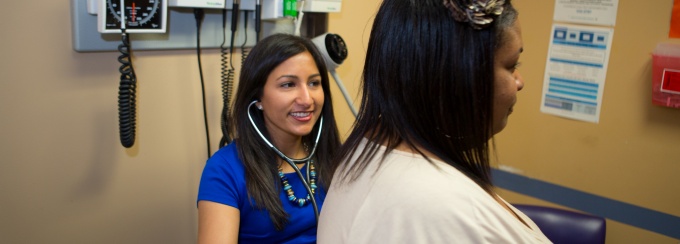 Medical practioner performing check-up on woman. 