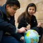 Two students holding a globe. 