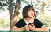 Asian woman holding a smartphone. 